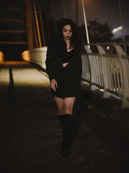 A full-length walking shot from the night series, with dramatic lighting and shadows.
