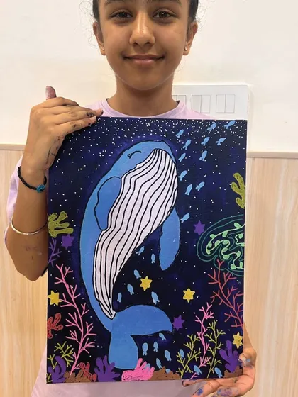 A happy student proudly displays her vibrant whale painting, created during one of my personalized art workshops. My goal is to create a supportive space where every artist can explore their style and finish a piece that feels uniquely their own.