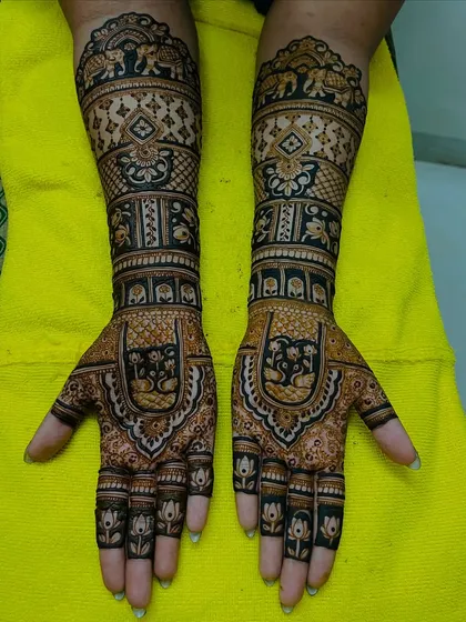 A full-coverage bridal design featuring classic Indian motifs like elephants and swans. The intricate patterns and dark stain are a result of our 100% organic henna and experienced artists.
