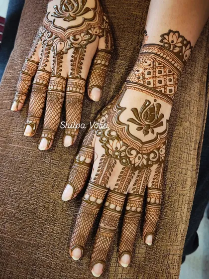 A beautiful lotus-themed design with delicate net patterns on the fingers and a full design on the back of the hand.