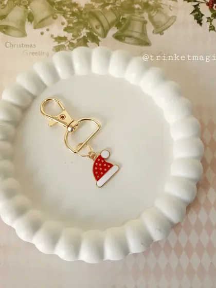 Unlock the magic of Christmas with this simple Santa hat charm keychain. It's a cute and minimal way to add a festive touch.