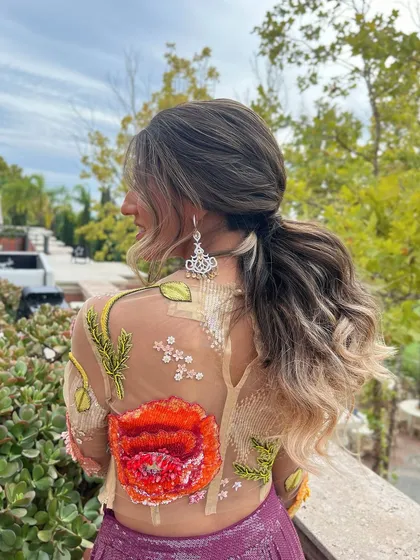 A side view of the wavy low ponytail, showing the beautiful ombre hair color.