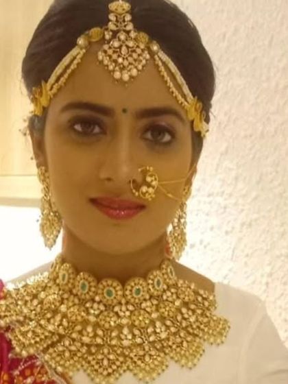 A direct portrait of the model wearing the stunning collar necklace and matha patti. The intricate work and design are clearly visible.