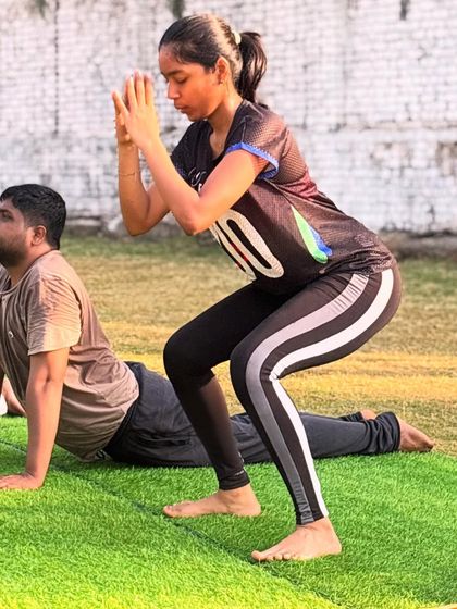 Members practice different yoga poses side-by-side, like the chair pose (Utkatasana) and cobra pose (Bhujangasana), showcasing the variety of movements in a single session.