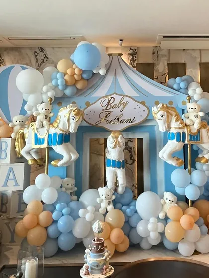 To welcome a baby boy, we designed a beautiful carousel-themed setup with pastel blue and peach balloons, classic carousel horses, and adorable teddy bears.