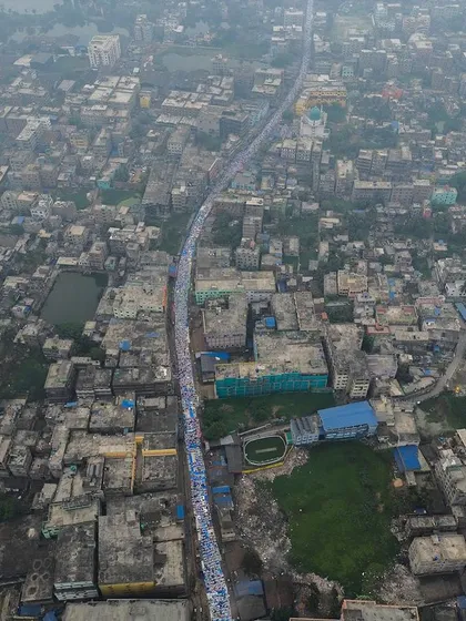 A high-altitude drone shot showing the line of worshippers for Eid prayers stretching far down a main road in Kolkata. It provides a powerful context of the city and the scale of the event.