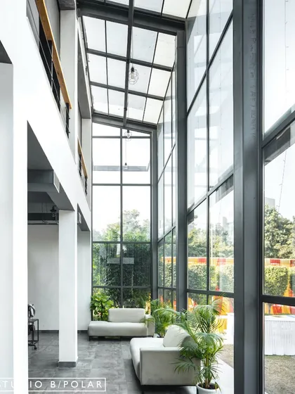 For the Media Monks campus, we designed a double-height glass atrium that floods the interior with natural light and seamlessly connects the workspace to the surrounding landscape. This architectural feature creates a sense of openness and transparency, fostering a collaborative and refreshing work environment.