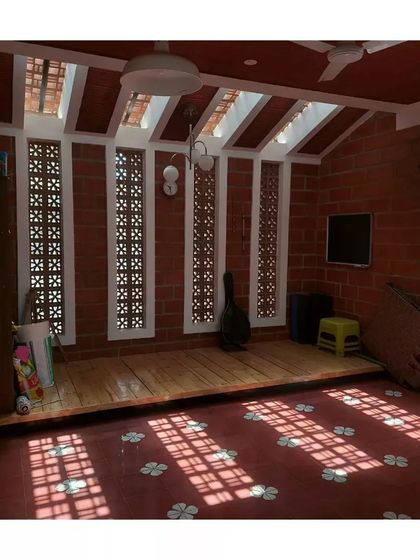 Sunlight filters through jaali windows and a skylight, casting beautiful patterns on the red oxide floor of this room in Secunderabad.