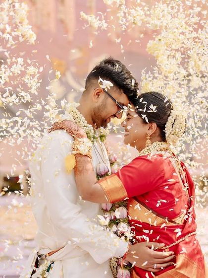 A romantic embrace under a shower of petals, a perfect, cinematic end to the wedding ceremony.