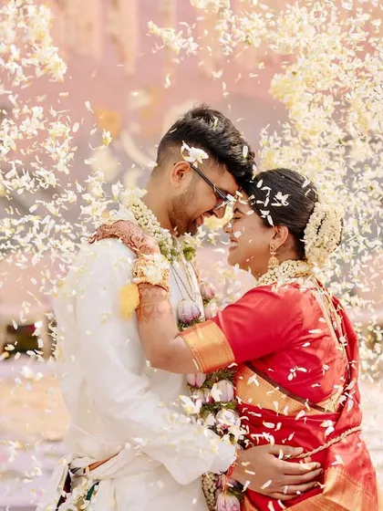 A romantic embrace under a shower of petals, a perfect, cinematic end to the wedding ceremony.