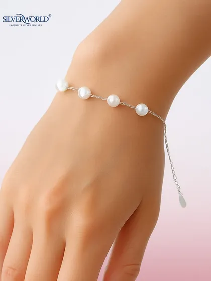 A classic pearl bracelet, with evenly spaced pearls on a delicate silver chain. This is a timeless piece of jewelry that exudes elegance.