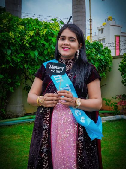 A happy mom-to-be wears a "Mommy to be" sash and holds a matching prop. This is a great way to add a fun, celebratory element to a traditional or modern maternity shoot.