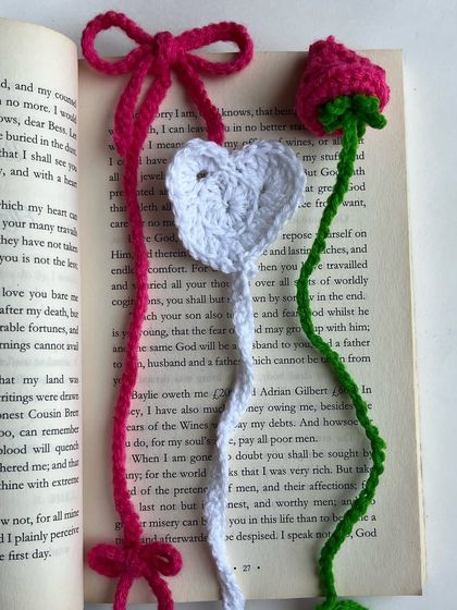 A collection of my handmade crochet bookmarks. This image features a coquette-style bow bookmark, a heart bookmark, and a rose bookmark, showing the variety of designs I can create for book lovers.