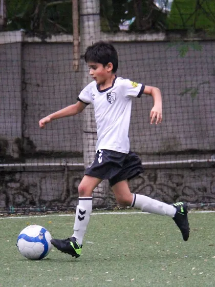 With a powerful run-up, this player is about to strike the ball, showing the dynamic movement and attacking skills we cultivate.