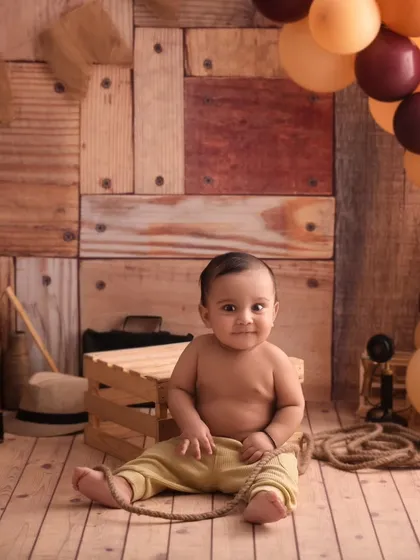 A full view of the cowboy setup, complete with rustic wooden crates, balloons, and a very cute baby.