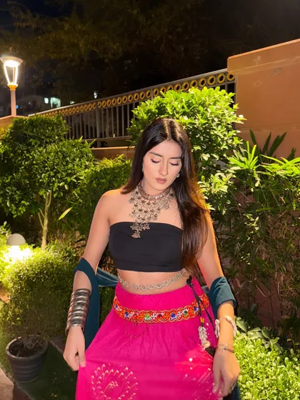 Looking down at the details of my pink lehenga, which has beautiful embroidery at the hem.