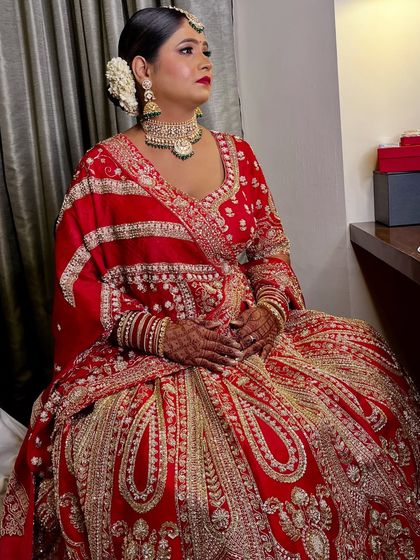 A moment of quiet elegance. Her traditional red lehenga is paired with a classic makeup look, featuring a flawless base and a beautiful floral gajra bun.