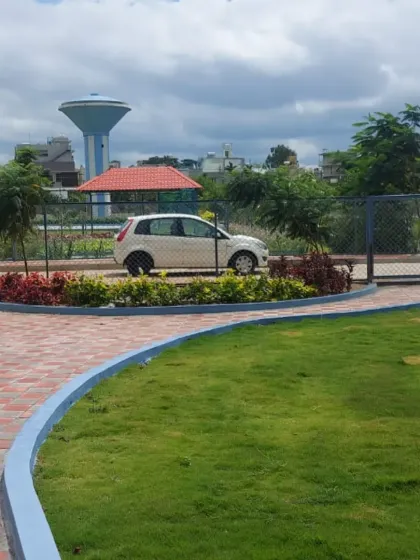 The entrance to a gated community or park, with a curved driveway and colorful border planting. A well-designed entrance landscape creates a strong first impression.