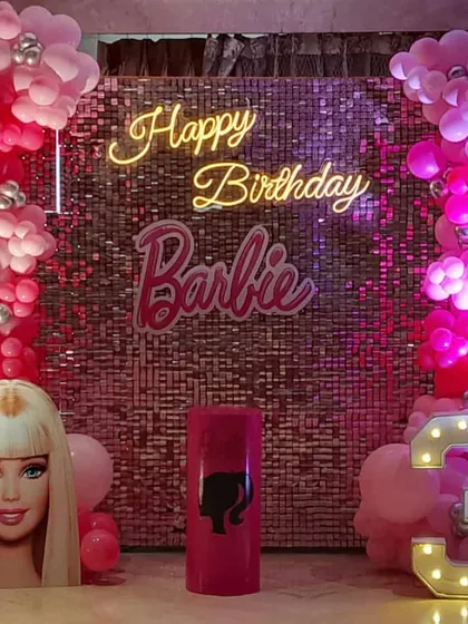 It's a Barbie world! This glamorous Barbie-themed birthday features a pink sequin wall, a neon "Happy Birthday Barbie" sign, and a life-sized Barbie head cutout for the perfect photo opportunity.