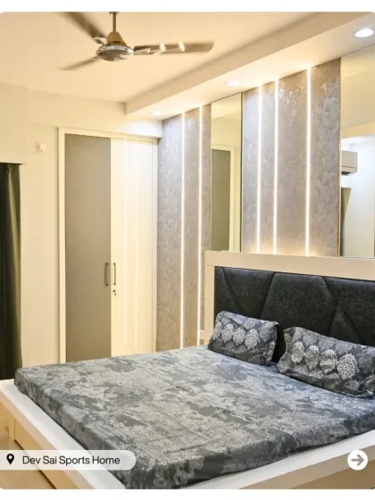 A close-up of the master bedroom from Dev Sai Sports Home, showing the textured wall panels and integrated lighting that create a sophisticated ambiance.