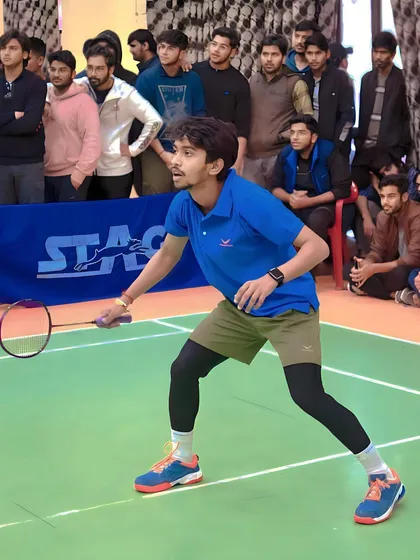 One of our players in a competitive tournament setting, focused and ready for the next shot, with spectators watching in the background.