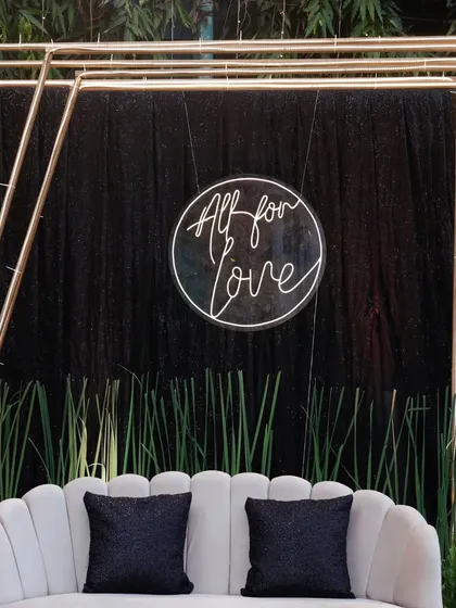 A chic and modern photo booth we designed for a Sangeet. The "All for Love" neon sign against a black sequin backdrop was a hit with the guests.