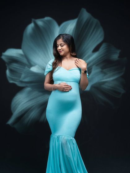 Elegance personified. This stunning mumma-to-be exudes serenity and grace in a soft, sea-blue gown against a floral backdrop.