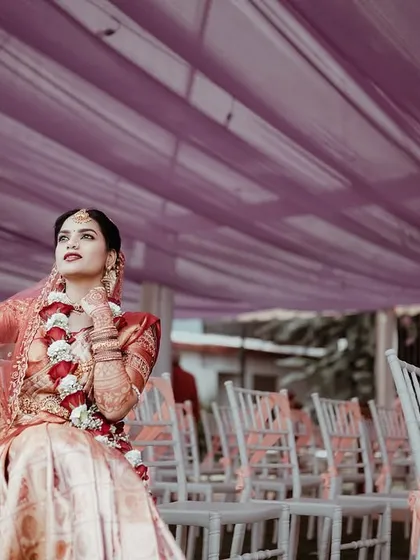 The bride strikes a pose under the vibrant purple wedding tent. This shot captures her confidence and the celebratory atmosphere of the outdoor venue.