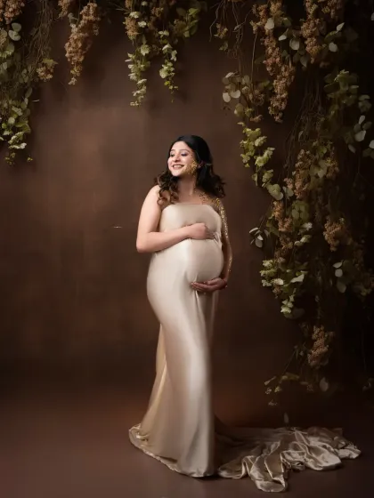A joyful smile from a glowing mother-to-be. This portrait in a champagne-colored gown captures a moment of pure happiness and anticipation.