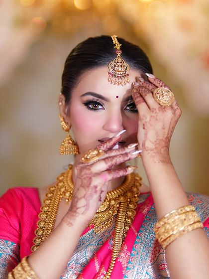 A coy and beautiful pose. The nude lipstick is a modern touch that balances the traditional gold elements of the look perfectly.