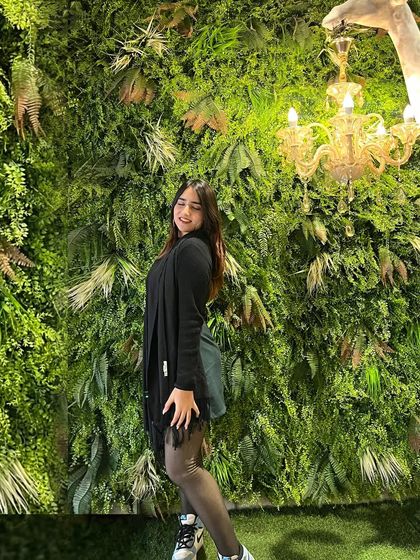 A different pose against the green wall. This shows versatility even in a simple setting.