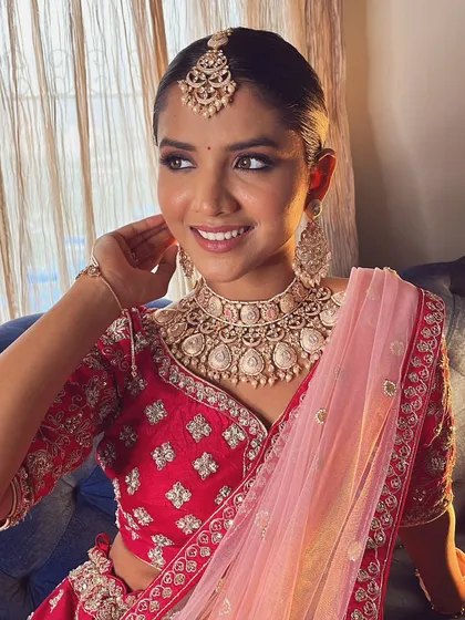 A traditional bridal look with a modern twist. The clean, sleek bun and soft makeup create a timeless and elegant style.
