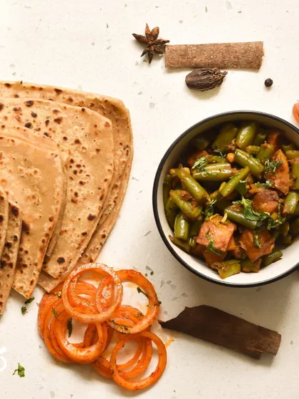 A simple and satisfying vegetarian meal. This plate features a delicious preparation of beans and potatoes, served with soft rotis. It’s a perfect example of my daily, home-style cooking.
