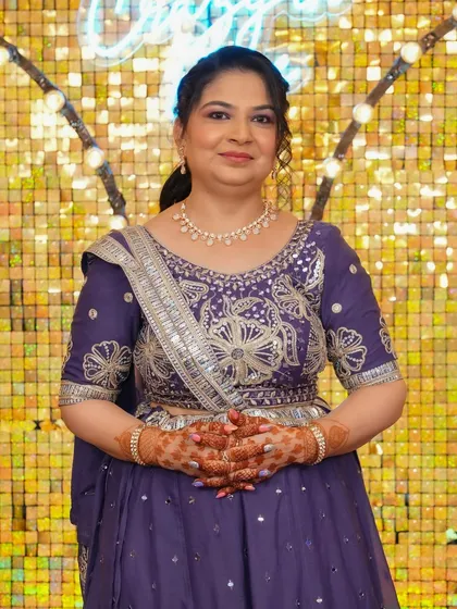 A full-length view of the client in her gorgeous purple outfit. The makeup and simple hair updo create a balanced and elegant silhouette.