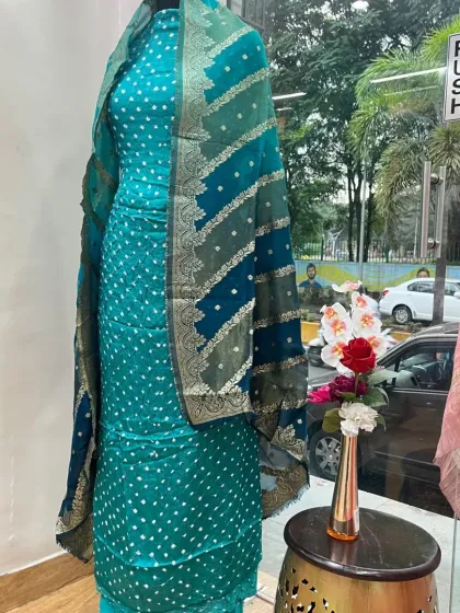 A stunning Banarasi Bandhej suit displayed in my boutique. The combination of the tie-dye technique with woven Banarasi borders creates a rich, festive look that can be custom-tailored.