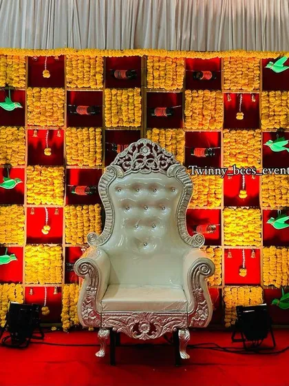For a truly traditional seemantham or baby shower, we designed this vibrant backdrop. It features a grid of fresh marigold flowers, accented with paper parrots and hanging bangles, creating a festive and colorful setting for the mom-to-be.