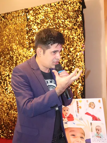 Another look at me hosting, mic in hand, against a glittering gold backdrop. I am always ready to bring the energy and make your event shine.