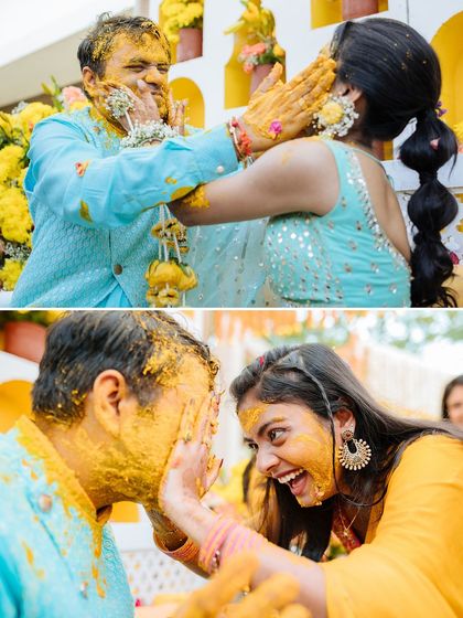 A playful moment between friends as the bride and groom get lovingly smeared with turmeric paste during their Udaipur Haldi.