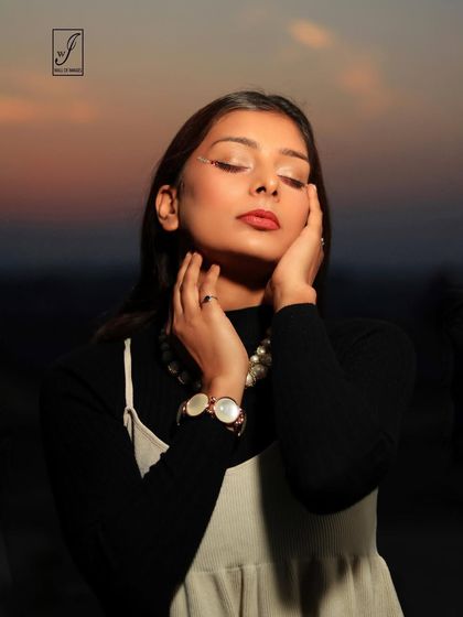 An intimate beauty shot taken during sunset, with the soft light highlighting the model's features and the subtle shimmer on her eyelids.