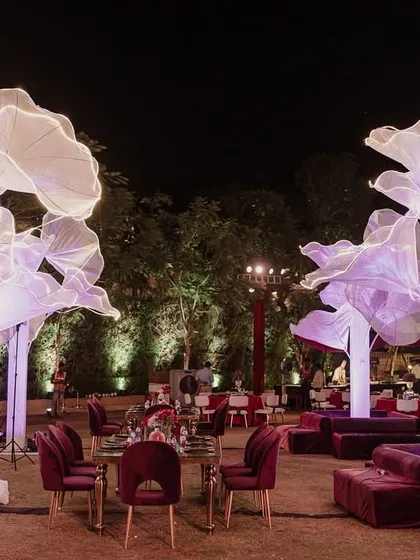 Giant, illuminated floral installations were the centerpiece of 'The Scarlet Soirée'. These artistic structures added a touch of surreal beauty and soft light to the outdoor evening event.