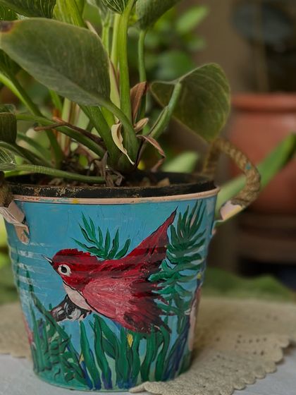Another beautiful bird-themed planter from the set my mom painted. The soft blue background and red bird create a serene, nature-inspired look.
