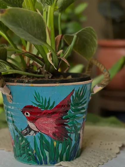 A new set of planters painted by my dearest mom, this one featuring a red bird in a lush green setting.