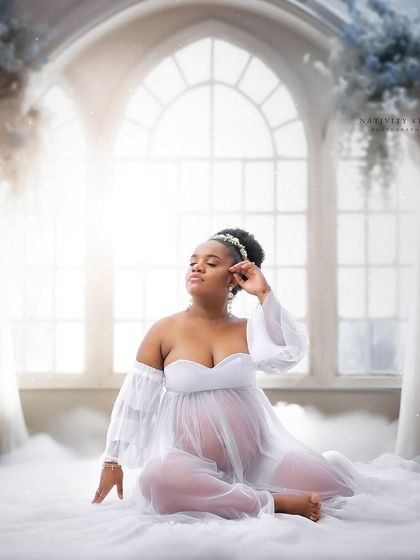A dreamy, heaven-like setup with clouds and ethereal light. This fine art portrait in a white gown is truly magical.