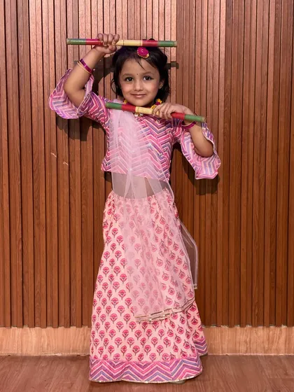 Posing with her dandiya sticks, this student is all smiles in her pink lehenga. We focus on making learning traditional dance forms an exciting and enjoyable experience.