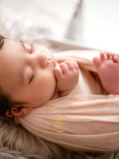 A close-up of a sleeping newborn's face, showing the delicate features and peaceful expression I aim to capture.
