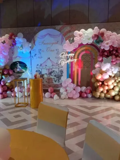 A carousel-themed first birthday party with a custom backdrop and colorful balloon arrangements.
