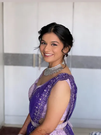 The bride looks so happy with her floral updo. This style is perfect for an engagement or sangeet, adding a touch of freshness to her look.