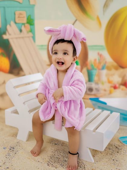 Relaxing after a long day at the beach. This adorable shot features a baby in a pink bathrobe, adding a cute and funny twist to the beach theme.