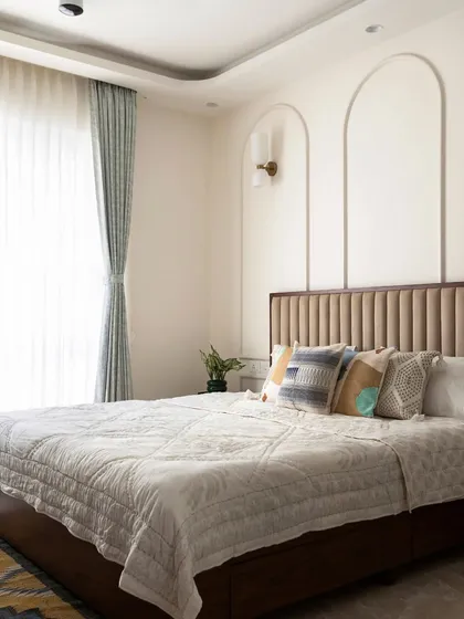 A full view of the master bedroom, showing the elegant false ceiling detail, the flowy curtains, and the overall sophisticated and restful atmosphere.