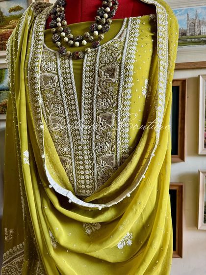 A full view of the suit on a mannequin, showing its rich color and the graceful drape of the georgette dupatta.